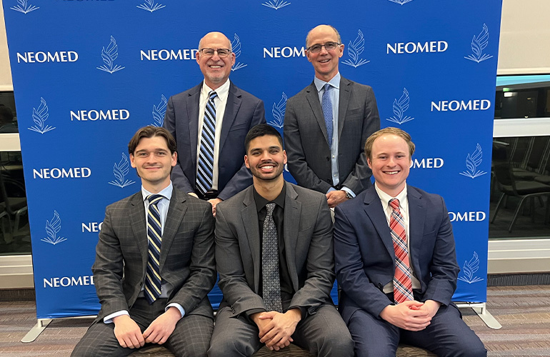 Current NEOMED AOA officers pose in front of a NEOMED backdrop