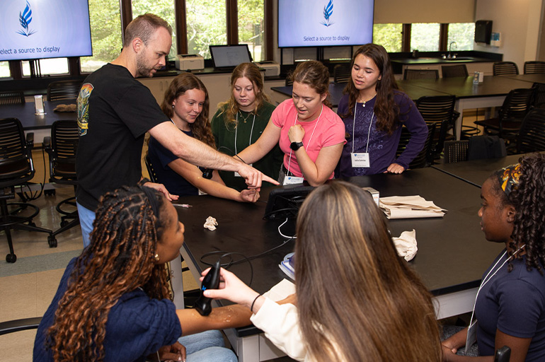 A group of young people observe a medical exam