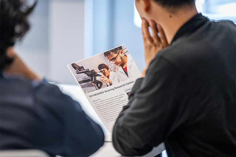 two people look at aa printed article