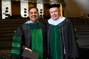 Two men wear the academic regalia of the NEOMED College of Medicine