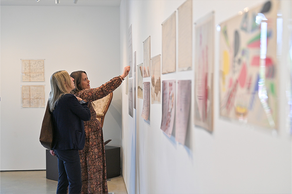 two women discuss a display in the exhibit in Peg's Gallery