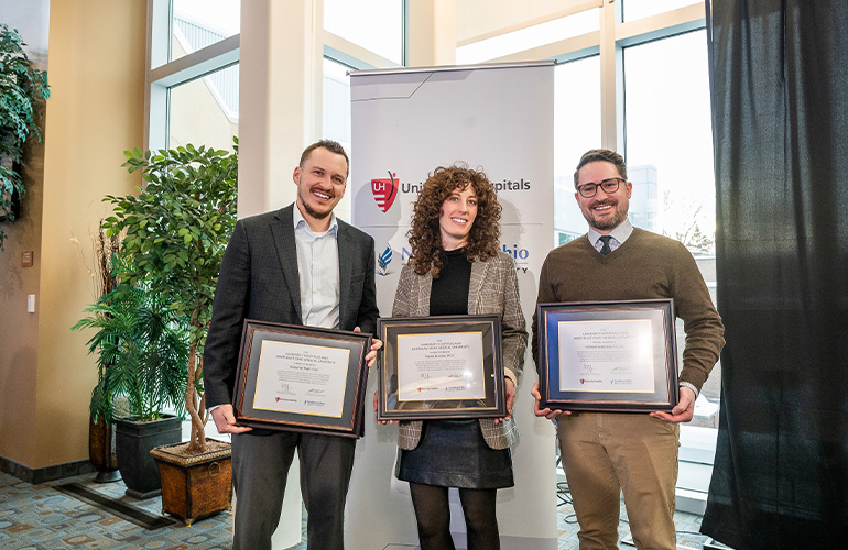 Nate Flath, Dr. Rachel Bracken and Mike Appleman pose with their scholar certificates