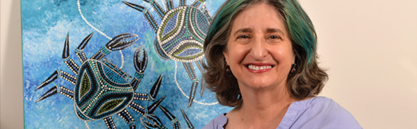 Rebecca German, Ph.D., in front of a painting