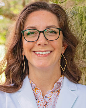 A portrait of a scientist in a white coat outdoors.