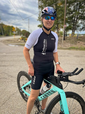 A woman in a helmet sits on her racing bicycle.