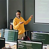 A faculty member gestures while leading a classroom discussion.