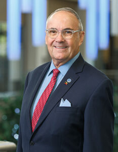 Headshot of Dr. Forrest Faison in blue suit jacket and red tie