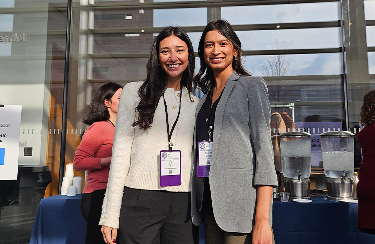 Two young women wearing conference lanyards