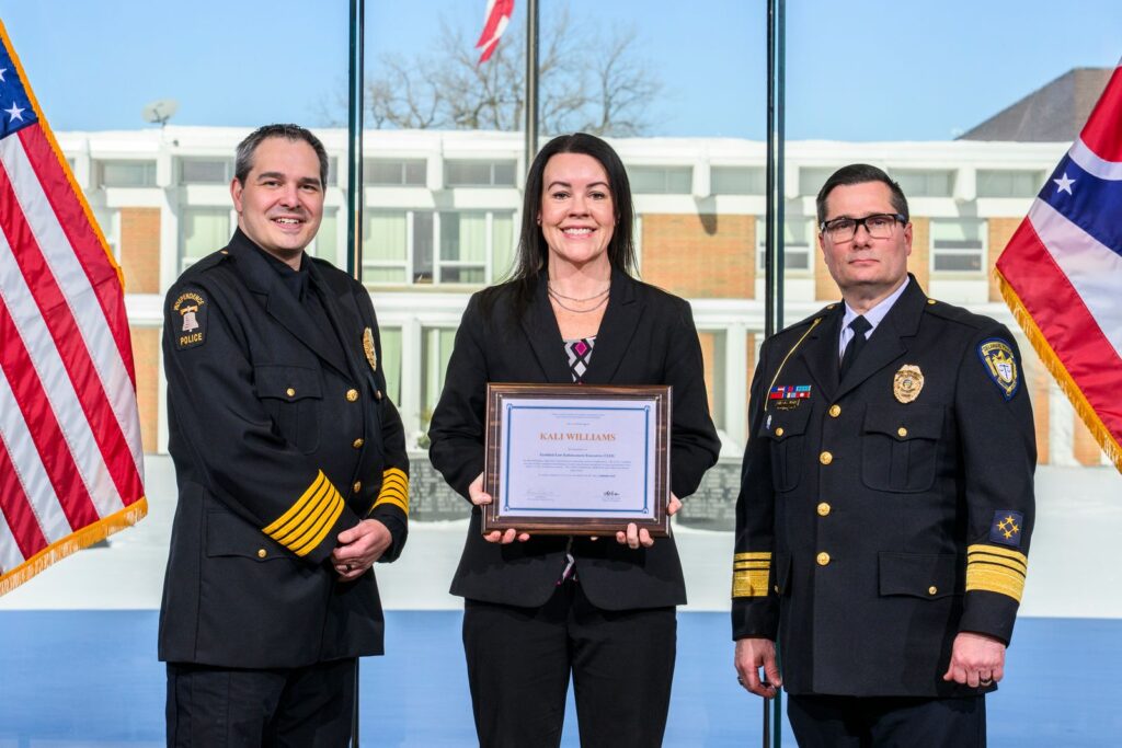 Kali Williams holds her CLEE certificate while posing with two other police officers