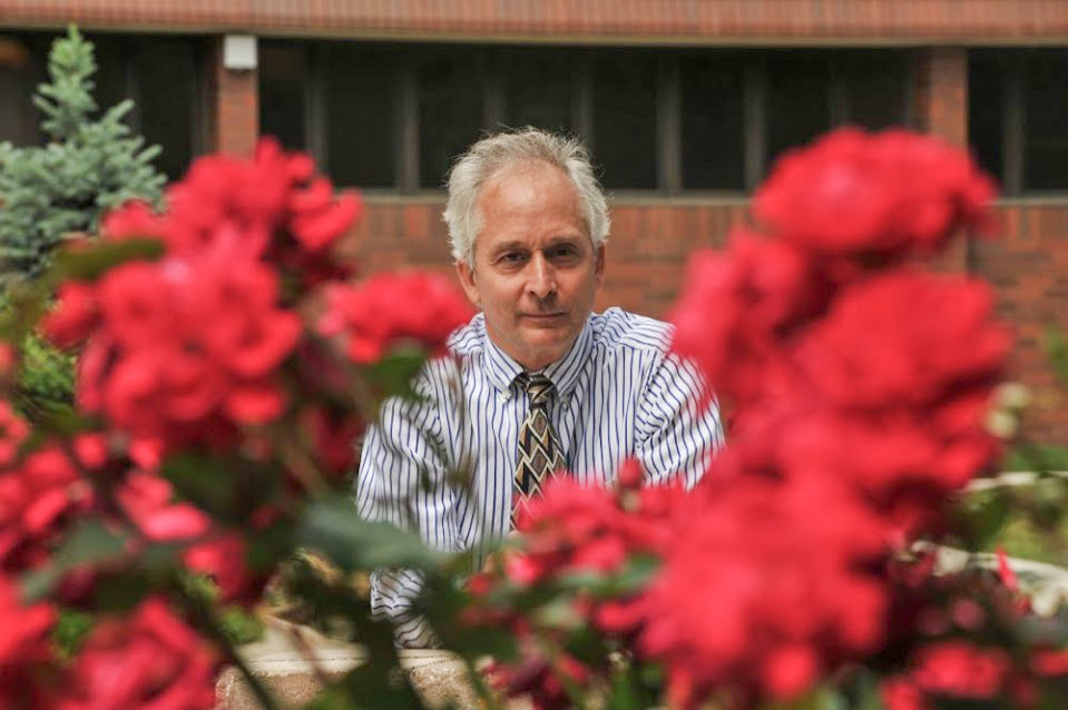 Paul Hartung Dr. Paul Hartung appears between two flowers in the foreground.