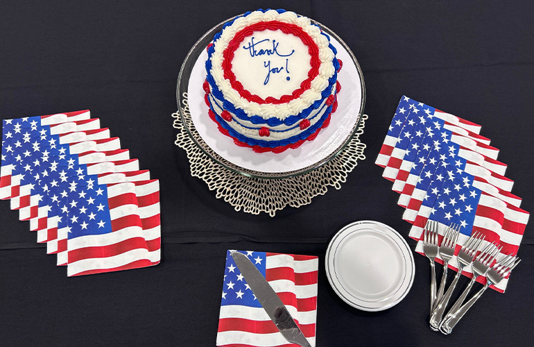 round cake decorated in red, white and blue with napkins depicting the American flag