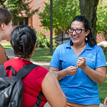 A staff member chats with a student at a campus picnic.