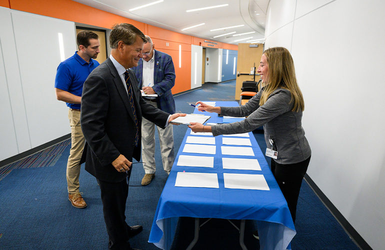 man in suit checks in at a registration table