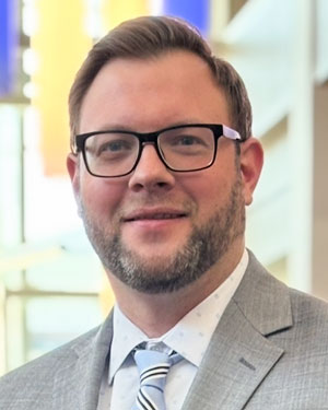 Aaron Clark in a coat and tie.