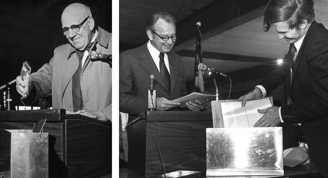 Men placing objects into a time capsule.