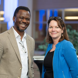 Two researchers in professional attire smile during an event at NEOMED.