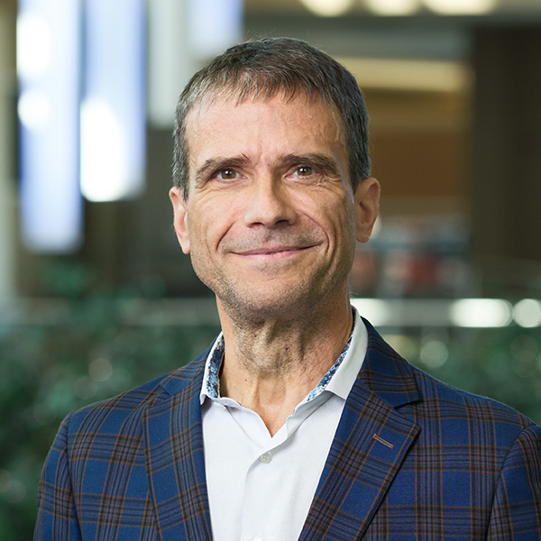A man in open collared button down shirt and jacket
