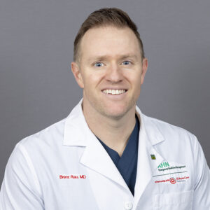Headshot of Dr. Brent Rau in white coat against a neutral background