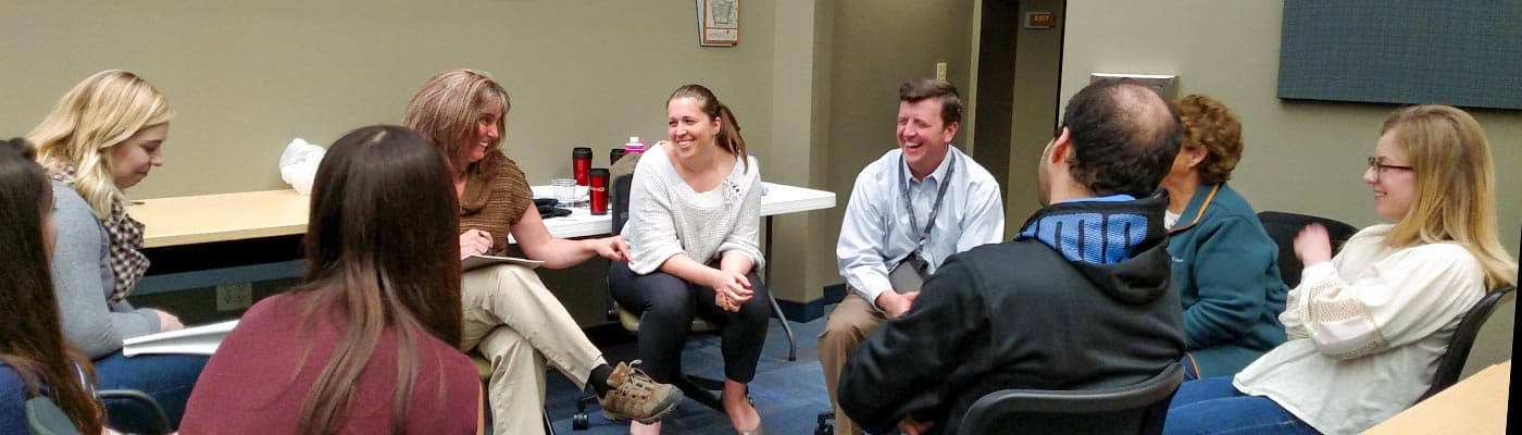 Students in the Master of Public Health degree program talk about an issue around a table.