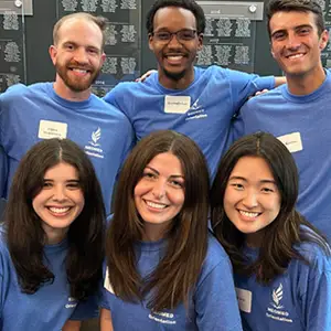 A group of NEOMED students in matching blue T-shirts.