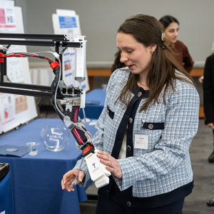 A woman demonstrates a robotic arm.