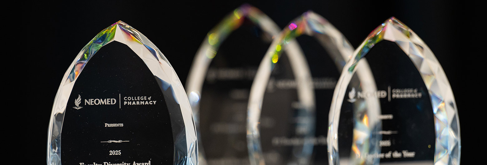 Four glass pharmacy awards on a table.