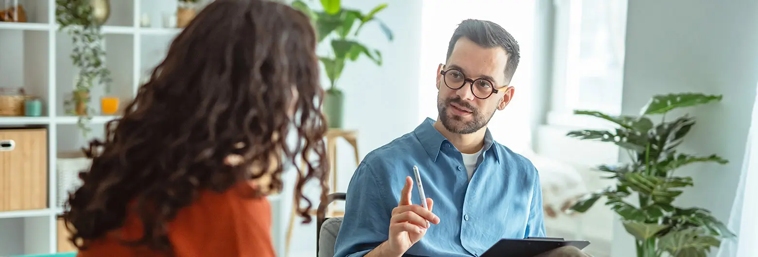 A certified mental health assistant talks with a client during a counseling session.