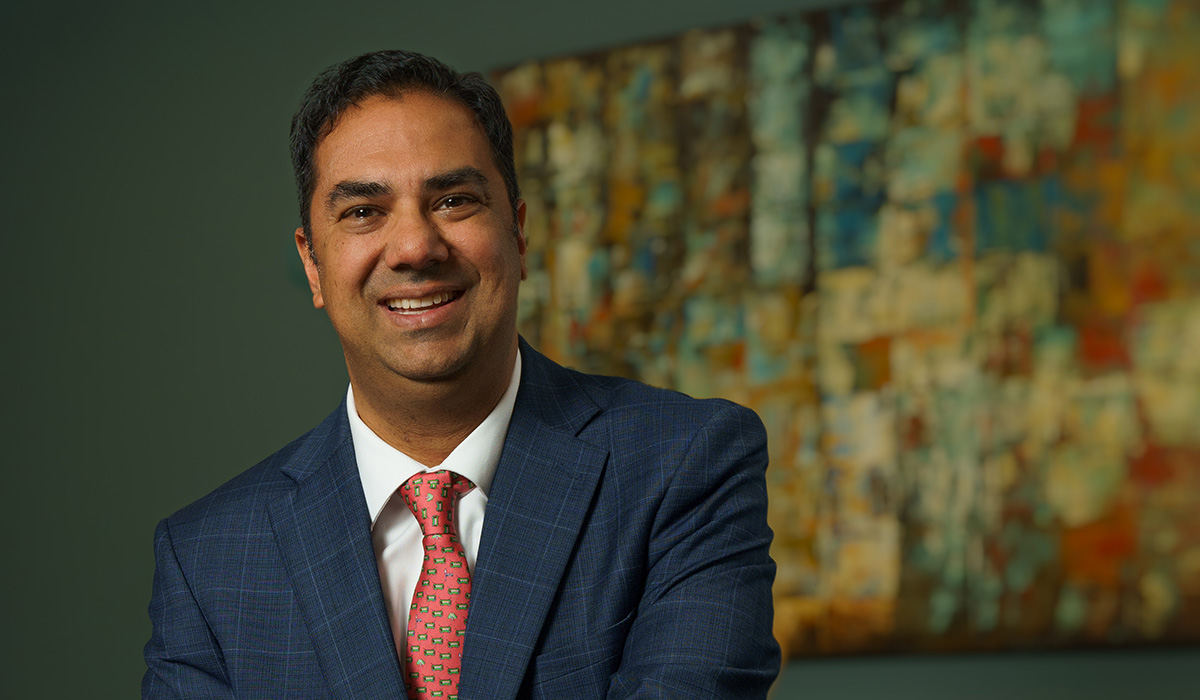 Amol Soin, a man smiling and wearing a tuxedo and red tie