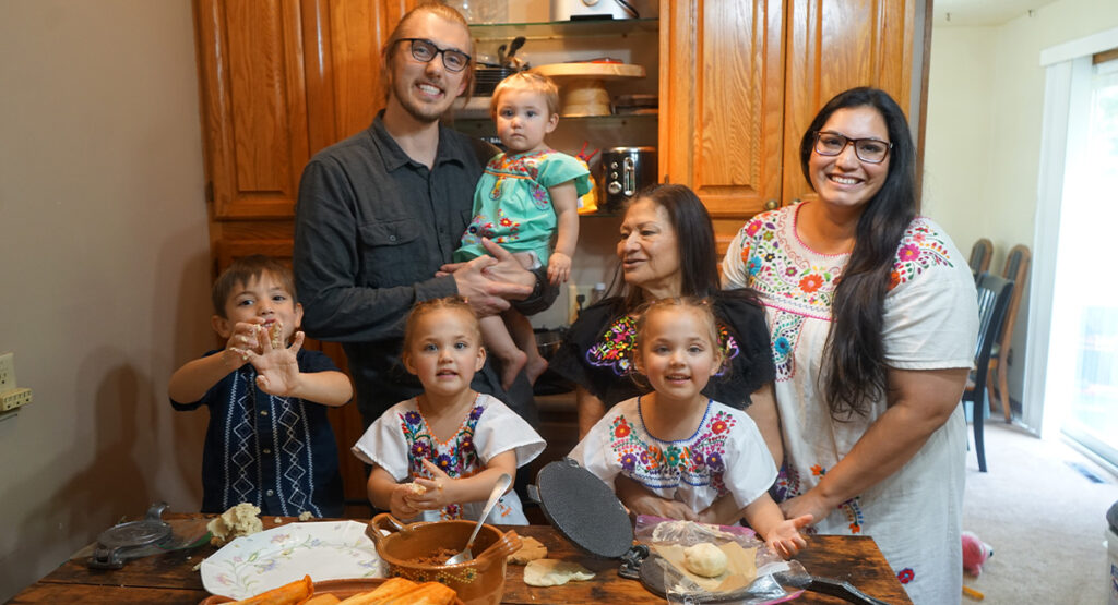 Three generations of a family gather around the kitchen table