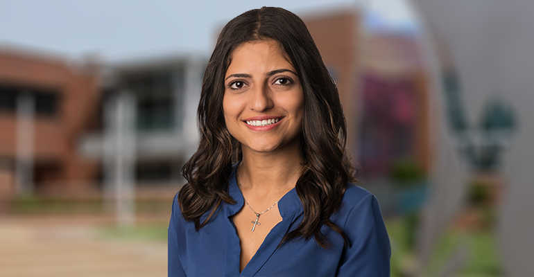 Headshot of Marian Khalil with campus photo blurred in the background