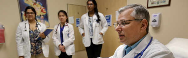 Doctor and students in examination room.