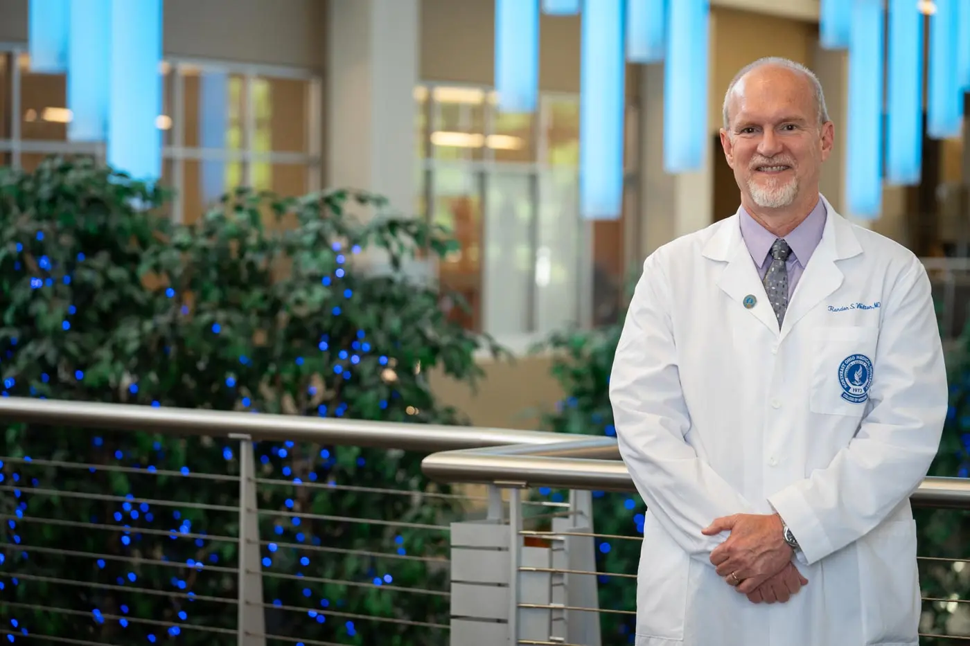 A physician in a white coat in the artium at NEOMED.
