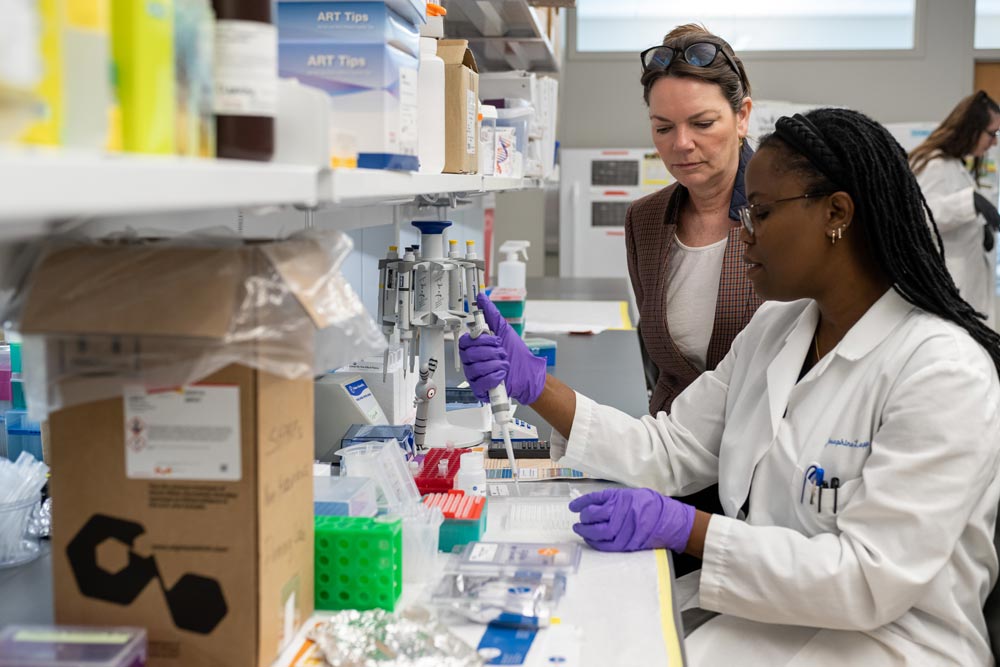 Sheila Fleming, Ph.D., looks on as Josephine Lepp pipes samples.