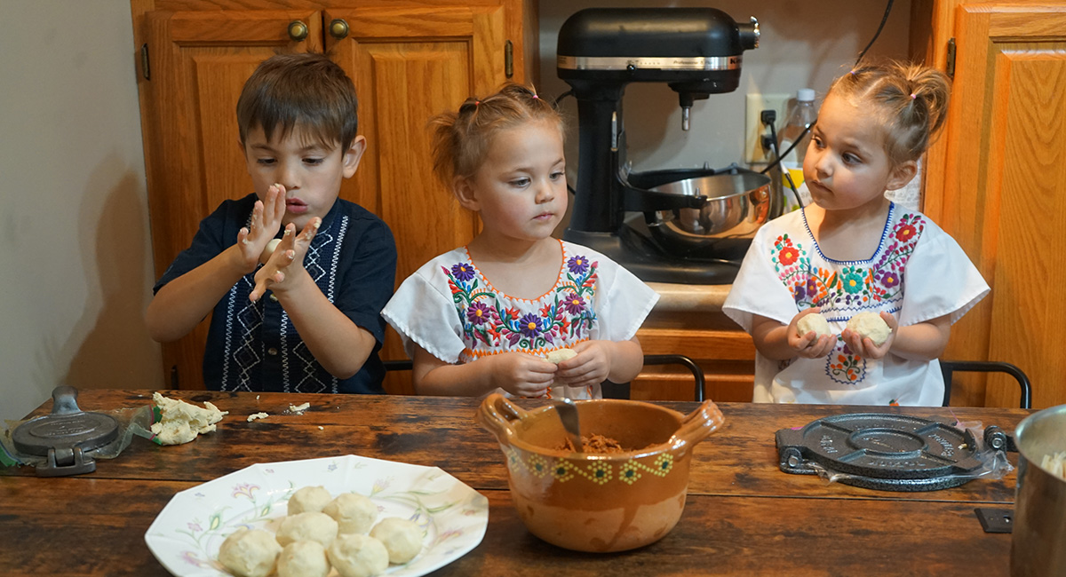 Three children help in the kitchen