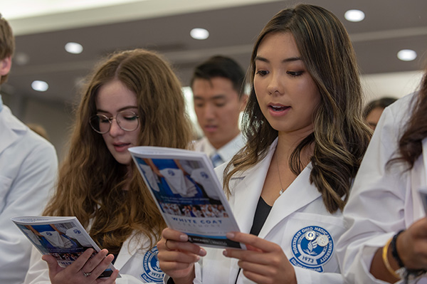 First-year medicine students reading the Oath of Professional Commitment