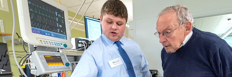 A CAA student demonstrates equipment in a simulation lab.