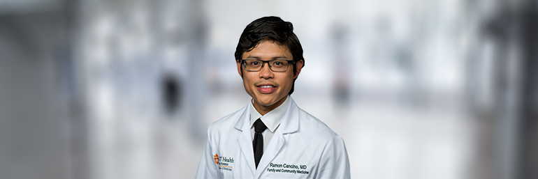 Male doctor in white coat against blurred background