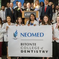NEOMED students hold a sign saying Bitonte College of Dentistry.