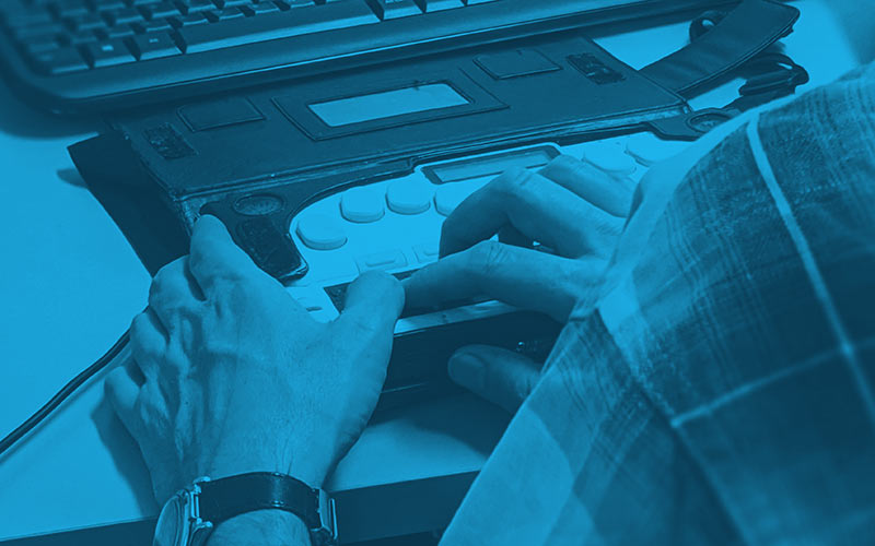 The hands of a man using an assistive device to guide a computer.