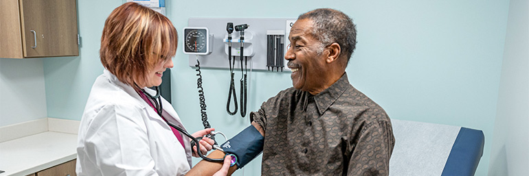 A doctor checks a patient's blood pressure.