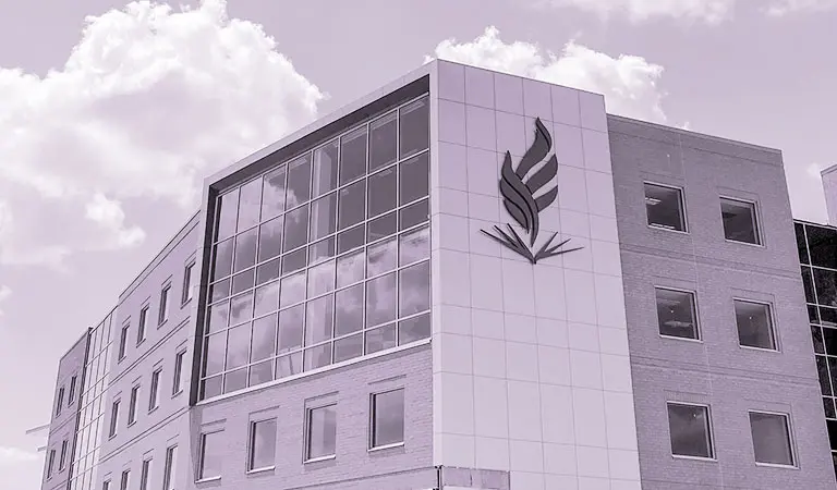 The exterior of NEOMED on a sunny day with dramatic clouds in the background.