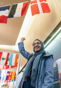 A NEOMED student points to the flag from her homeland.