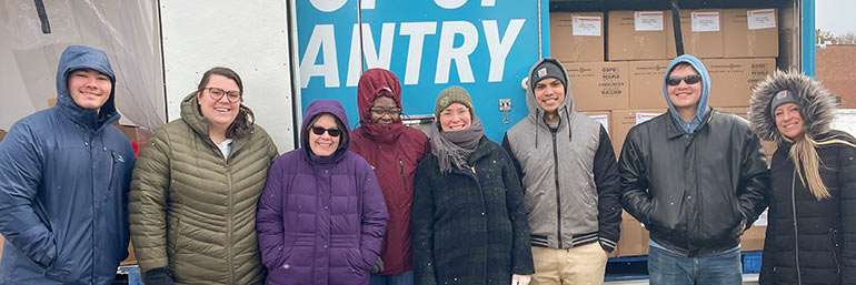 NEOMED students in winter gear help at a pop-up food pantry on campus in March.
