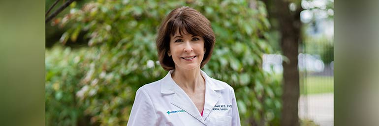 Nancy L. Gantt, M.D., FACS, professor of surgery and interim surgical chair at NEOMED, stands in a garden.