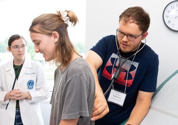 A Health Careers Camp attendee checks the heartbeat of a person acting as a patient.