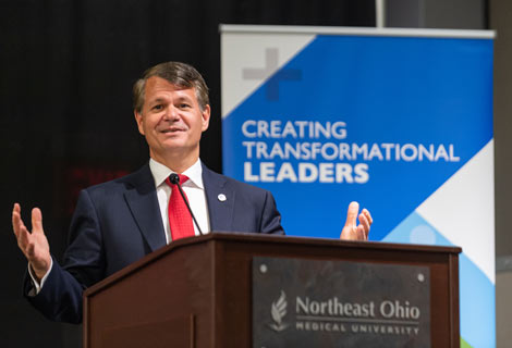 President Langell gestures while making remarks during an alumni event.