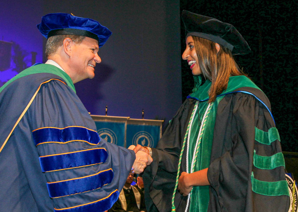 President John Langell congratulates a graduate at NEOMED Commencement.