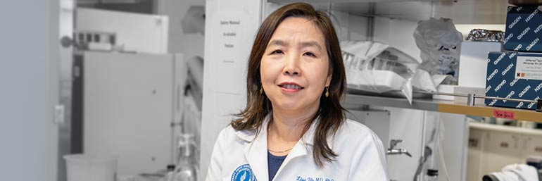 Liya Yin, M.D., Ph.D., stands in her lab.
