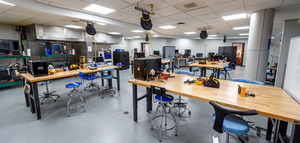 A maker space with long workbenches and a variety of tools by which students and entrepreneurs work together to develop new medical devices.