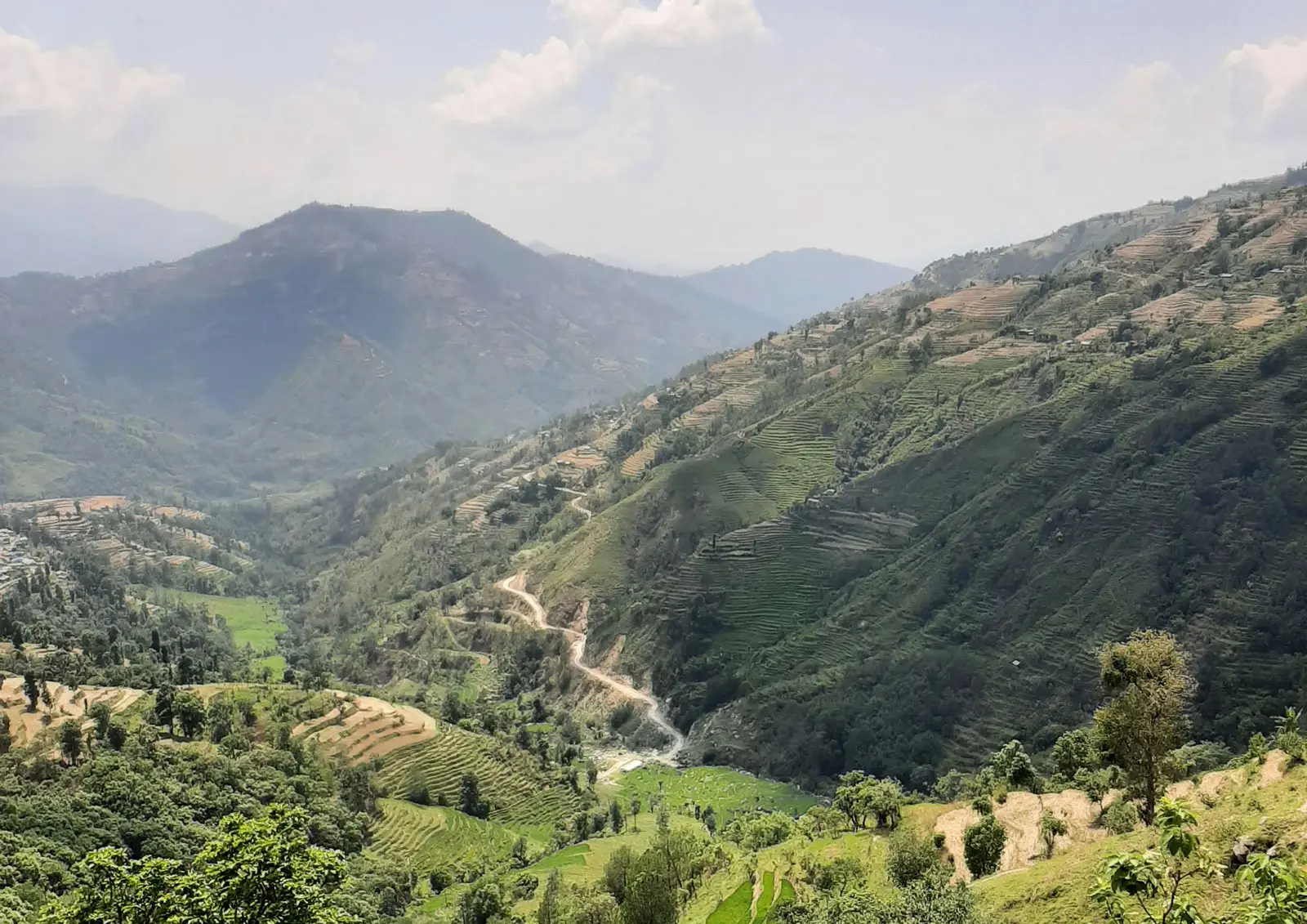 A road winds across a mountainside in Nepal.
